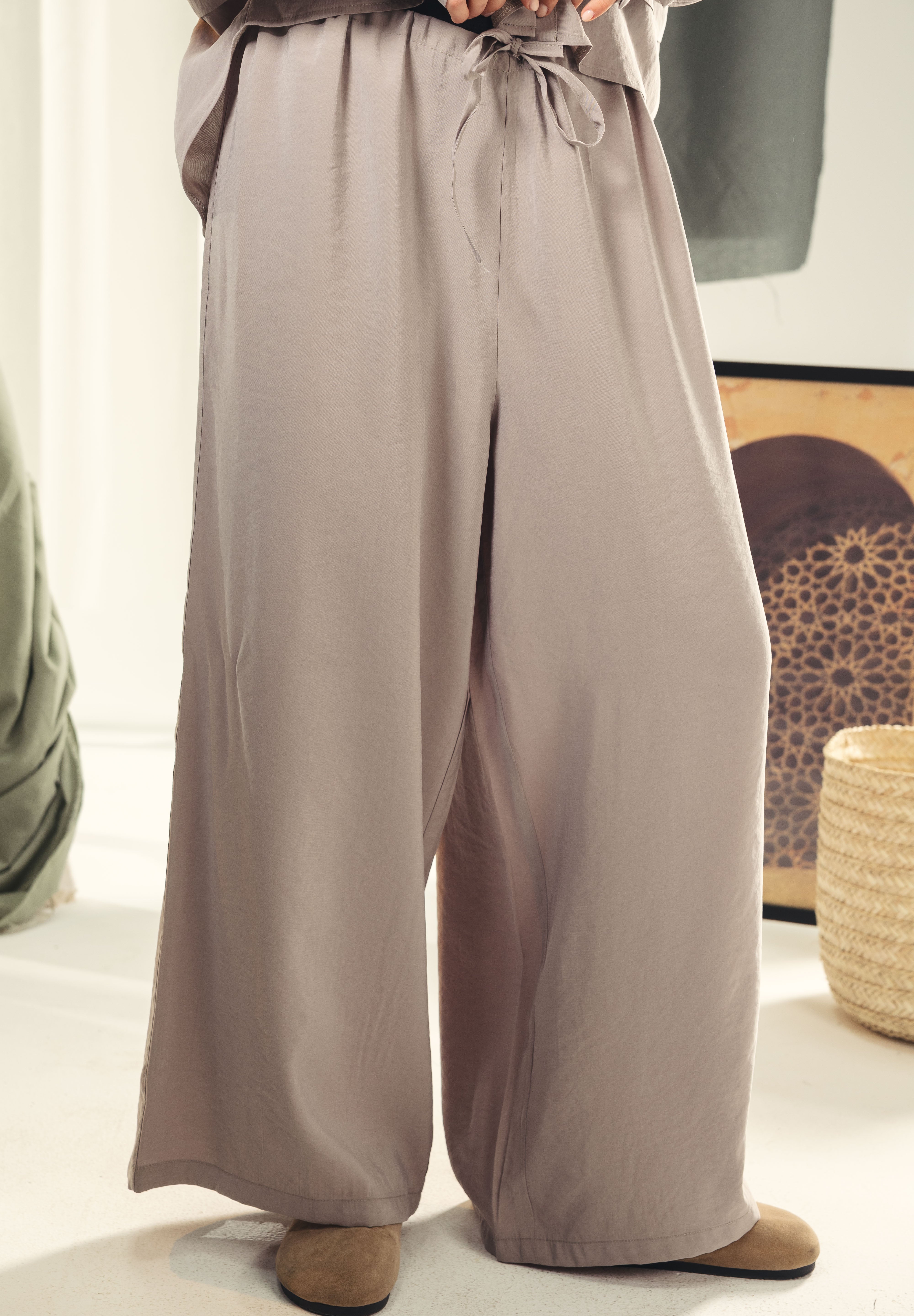 A wide leg copra pants with straw string for adjusting the waist Grey